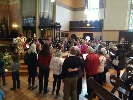 photo of people gathered to sing after the Easter service in 2016
